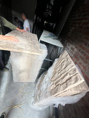 Hướng Dẫn Toàn Diện Về Tấm PU Gạch Thẻ Và Tấm PU Đá Thẻ Trong Kiến Trúc Hiện Đại Thị trường vật liệu hoàn thiện nội ngoại thất đang chứng kiến bước chuyển mình mạnh mẽ từ các dòng vật liệu truyền thống nặng nề sang các giải pháp công nghệ cao siêu nhẹ. Trong số đó, xu hướng sử dụng vật liệu Polyurethane (PU) cấu trúc foam mật độ cao đang chiếm lĩnh các bản vẽ thiết kế hiện đại. Nếu như khái niệm tổng thể về tấm pu giả đá đã khẳng định vị thế trong việc tái tạo vẻ đẹp thiên nhiên, thì hai biến thể chuyên sâu là tấm pu gạch thẻ và tấm pu đá thẻ lại mang đến giải pháp tinh tế, tỉ mỉ cho những mảng tường đòi hỏi tính điểm nhấn cao, kiến trúc phân lớp và sự linh hoạt trong thi công. 1. Tìm Hiểu Chi Tiết Bản Chất Kỹ Thuật 1.1 Tấm Pu gạch thẻ là gì? Tấm PU gạch thẻ là dòng vật liệu trang trí dạng tấm đúc sẵn từ hợp chất Polyurethane mật độ cao (High-Density Polyurethane Foam), mô phỏng chính xác hình dáng, kích thước và bề mặt của các mảng gạch thẻ kiến trúc (gạch móng, gạch xây thô, gạch gốm). Thay vì phải ốp từng viên gạch đơn lẻ tốn hàng tuần lễ, sản phẩm này tích hợp hàng trăm "viên gạch thẻ" trên một khối tấm lớn với các đường mạch (ron) được định hình chuẩn xác tuyệt đối từ khuôn đúc. 1.2 Tấm Pu đá thẻ là gì? Tương tự như biến thể gạch thẻ, tấm pu đá thẻ tái hiện cấu trúc của các thanh đá tự nhiên được chẻ nhỏ và ghép lớp (như đá chẻ, đá slate, đá tăm). Bề mặt của tấm đá thẻ sở hữu độ gồ ghề, góc cạnh chớp nhấp chênh lệch chiều sâu rõ rệt, tạo hiệu ứng thị giác 3D vô cùng chân thực dưới ánh sáng đèn trang trí.